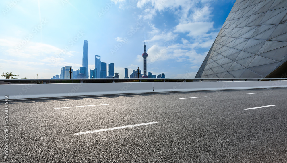 Empty asphalt road and backlit city skyline in Shanghai,China Empty asphalt road and backlit city skyline in Shanghai,China