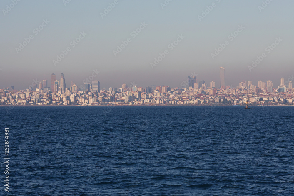 A view to Asian part of Istanbul from Marmara Sea. Evening time. Industrial mist above the city.Text-space. Outdoor shot