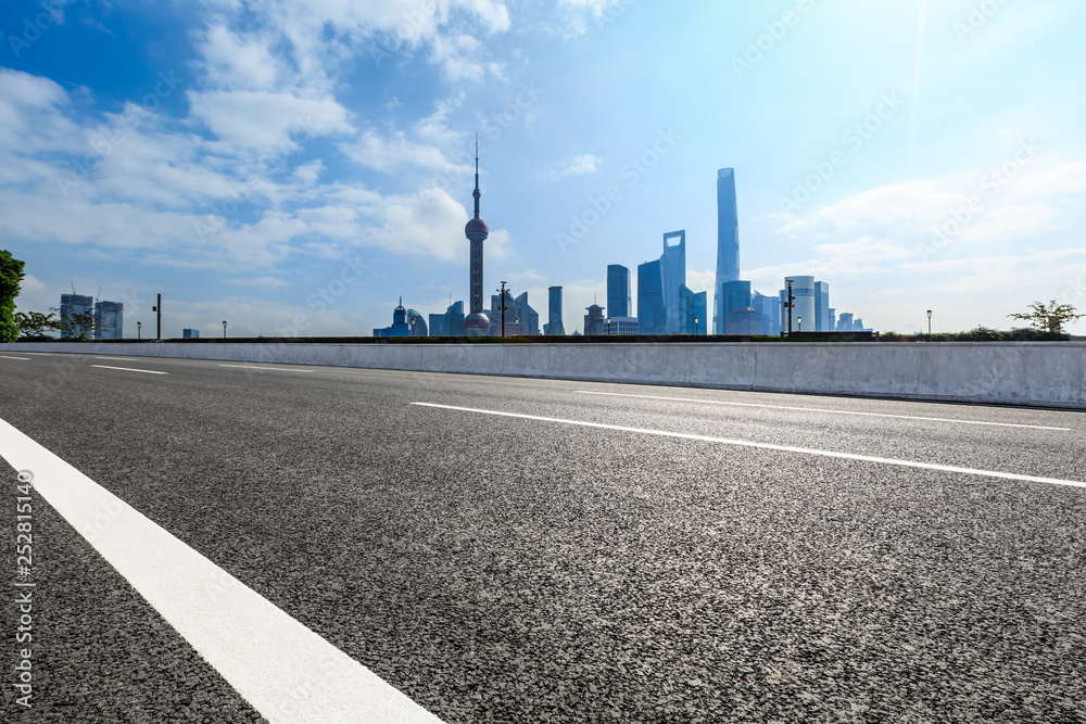 Empty asphalt road and backlit city skyline in Shanghai,China Empty asphalt road and backlit city skyline in Shanghai,China