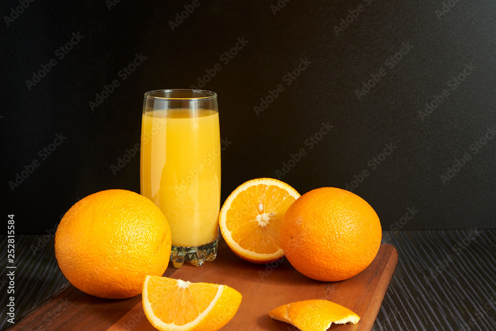 Oranges and juice on black background Oranges and juice on black background