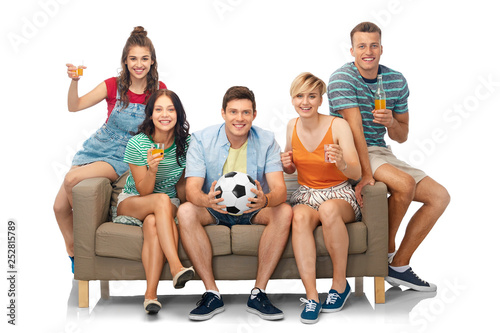 entertainment, leisure and people concept - group of happy smiling friends or football fans with soccer ball sitting on sofa with non alcoholic drinks over white background © Syda Productions