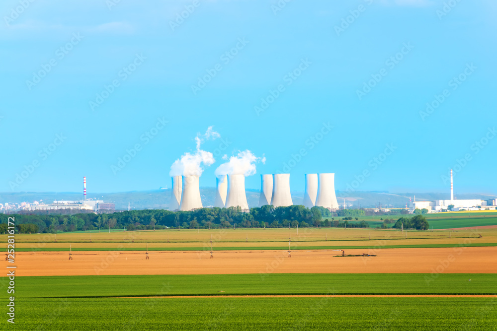 Agricultural fields with cooling towers of nuclear power plant in background