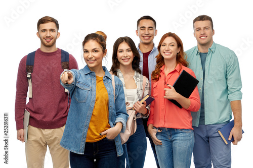 education, high school and people concept - group of smiling students with books and bags pointing at you over white background
