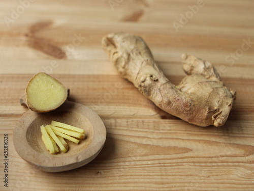 The ginger fruit is fresh, chopped finely, lies on a light wooden base, the concept of health and food photo