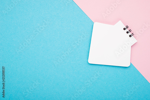 Empty Notebook or notepad on pink and blue background with a double color stationery. Creative minimalism chancery concept. Top view, flat lay. photo