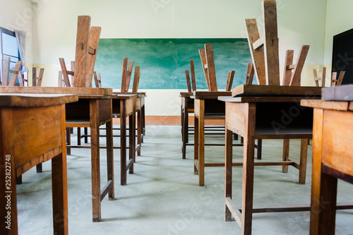 chair and table in class room with black board background, no student, school closed concept