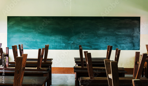chair and table in class room with black board background  no student  school closed concept