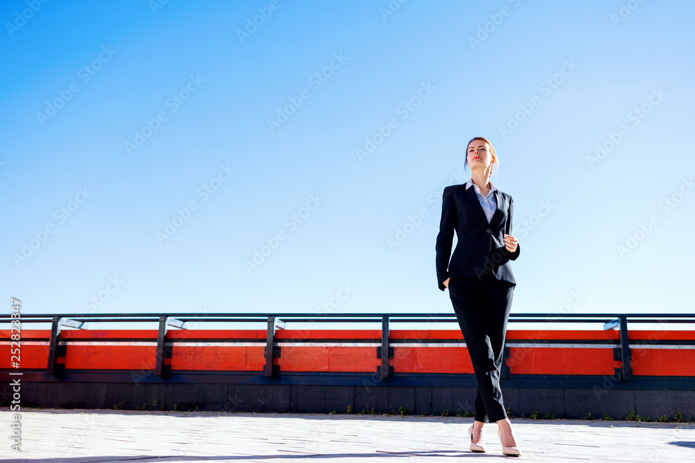 Business woman stands on observation deck.
