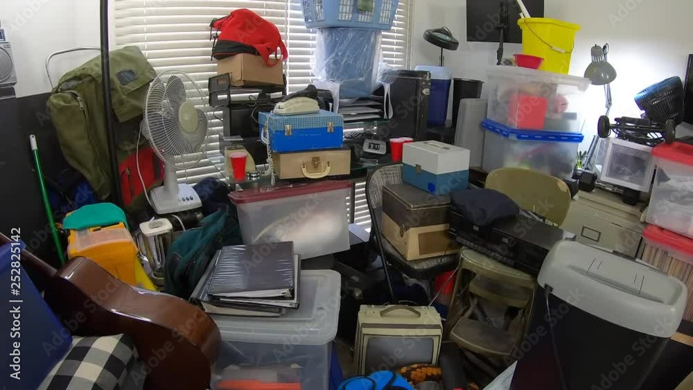 Dolly in through hoarder home room packed full of household items, vintage electronics, business equipment and miscellaneous junk.