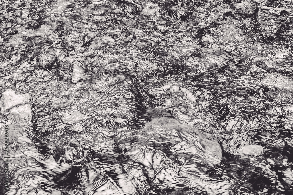Closeup of rough river water surface with water splashes in black and white. Abstract river, sea and ocean texture. Trendy elegant abstract nature background. Closeup of rough river water surface with water splashes in black and white. Abstract river, sea and ocean texture. Trendy elegant abstract nature background.