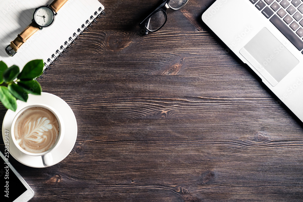 Business work desk workplace with laptop and gadgets on dark wooden table Business work desk workplace with laptop and gadgets on dark wooden table