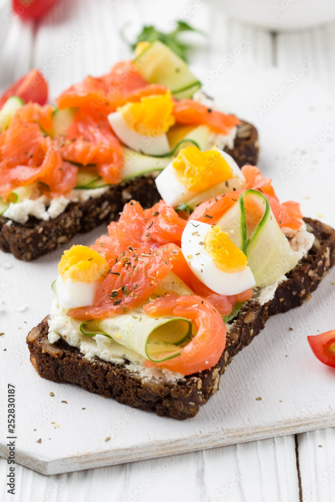 Salmon toast with cream cheese, cucumber and egg. Delicious lunch, healthy food, fish sandwich, diet snack Salmon toast with cream cheese, cucumber and egg. Delicious lunch, healthy food, fish sandwich, diet snack