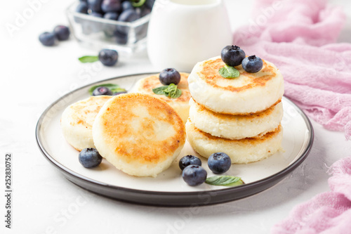 Cheesecakes from cottage cheese, delicious Breakfast, traditional Russian sweet pancakes. With blueberry, mint and sauce