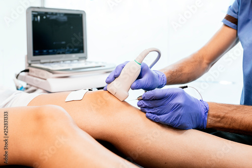 Physiotherapist giving knee therapy to a woman photo