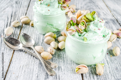 Vegan trend food. Homemade pistachio yogurt ice cream with fresh pistachios. On a white wooden table,