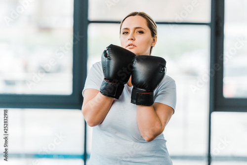 serious overweight girl standing in boxing gloves in gym © LIGHTFIELD STUDIOS