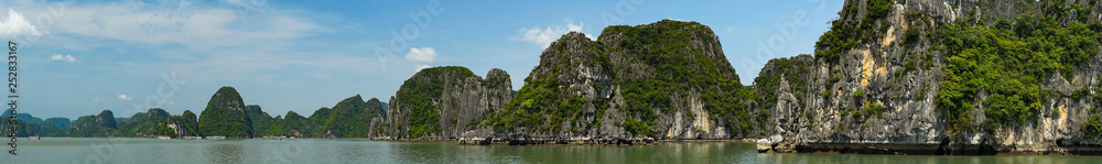 Scenic view of the Halong Bay (Descending Dragon Bay) at the Gulf of Tonkin of the South China Sea, Vietnam. Landscape formed by karst towers-isles in various sizes and shapes. Blue sky in background