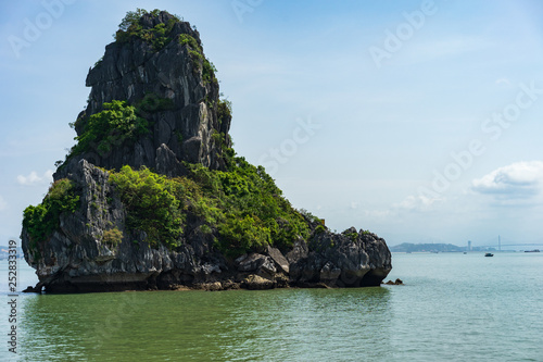 Scenic view of the Halong Bay (Descending Dragon Bay) at the Gulf of Tonkin of the South China Sea, Vietnam. Landscape formed by karst towers-isles in various sizes and shapes. Blue sky in background