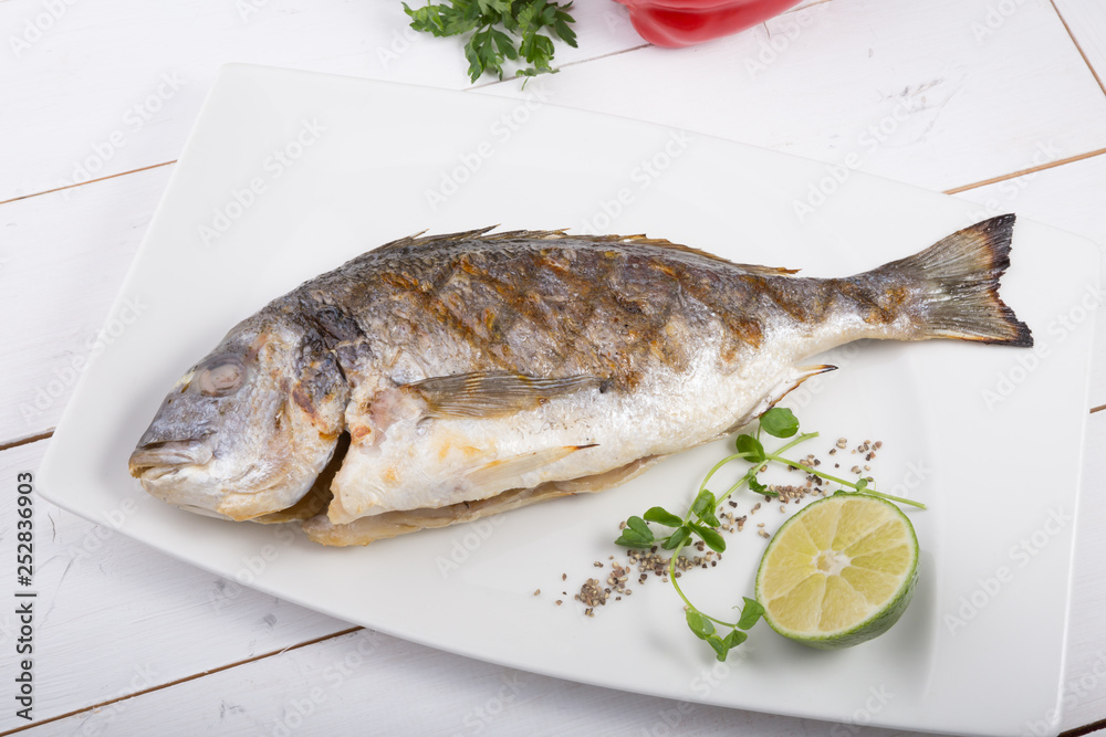 Grilled dorado fish served on a white plate Grilled dorado fish served on a white plate