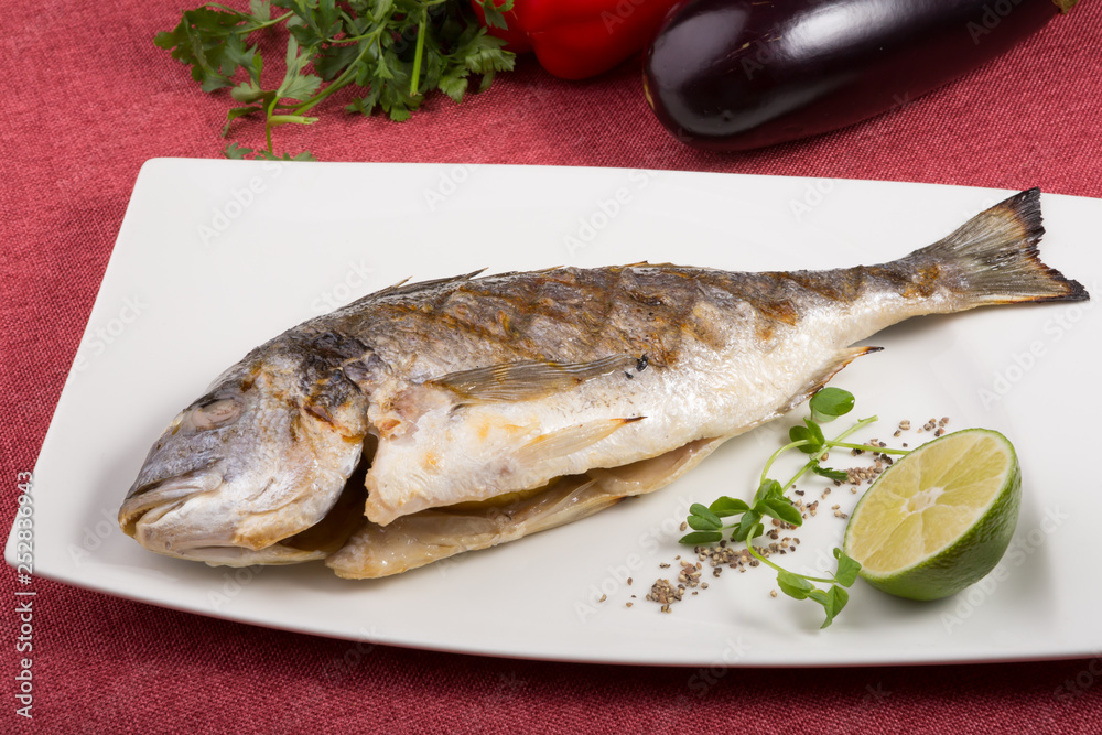Grilled dorado fish served on a white plate Grilled dorado fish served on a white plate