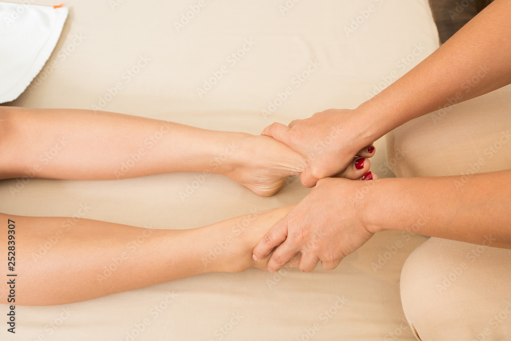 Professional Asian Therapist twist and massage spa on foot of customer to release stress relax muscle pain or injury. Physiotherapist pressing hard fingers thumb on specific spots of female palm feets Professional Asian Therapist twist and massage spa on foot of customer to release stress relax muscle pain or injury. Physiotherapist pressing hard fingers thumb on specific spots of female palm feets