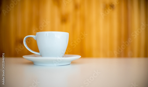 White porcelain cup over wooden background