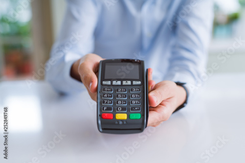 Obraz na plátne Close up of man hands holding pos terminal