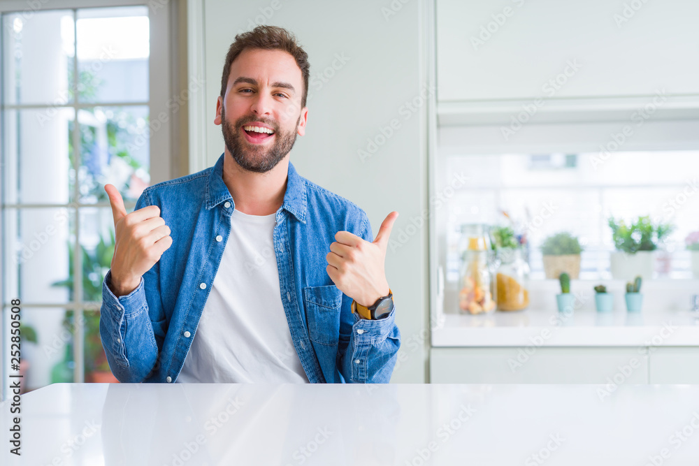 Handsome man at home success sign doing positive gesture with hand, thumbs up smiling and happy. Looking at the camera with cheerful expression, winner gesture. Handsome man at home success sign doing positive gesture with hand, thumbs up smiling and happy. Looking at the camera with cheerful expression, winner gesture.