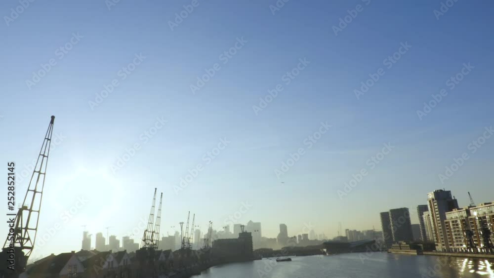 Airplane lands at sunset across the metropolis of London Airplane lands at sunset across the metropolis of London