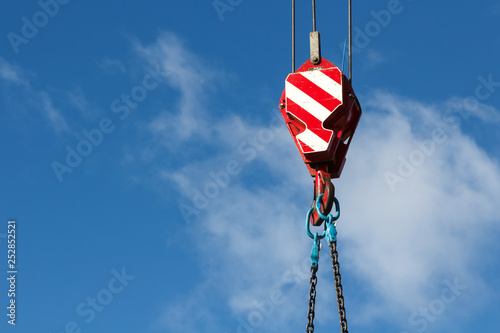 Mobile crane hook with chains, industrial background