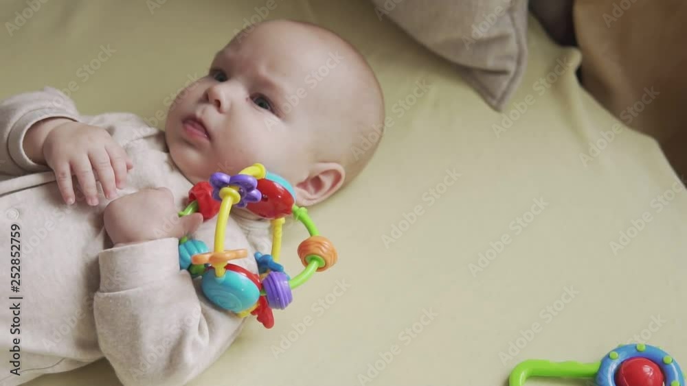 Cute little baby looking at camera and playing with toy. Concept of caring for children and parental love. Cute little baby looking at camera and playing with toy. Concept of caring for children and parental love.
