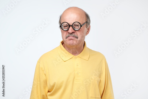 senior hispanic man looking at camera wearing funny glasses