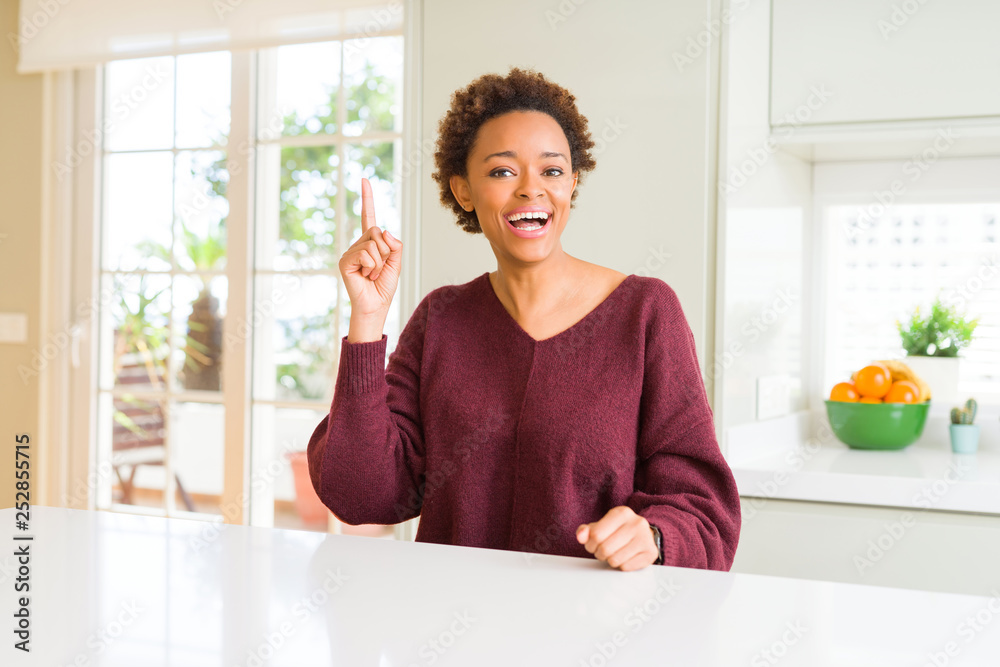 Young beautiful african american woman at home pointing finger up with successful idea. Exited and happy. Number one. Young beautiful african american woman at home pointing finger up with successful idea. Exited and happy. Number one.