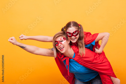 Mother and daughter dressed like superheros flying off to save the world from villans