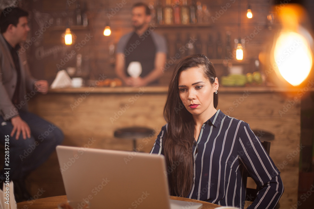 Young beautiful woman working on her laptop in vintage coffee shop. Young beautiful woman working on her laptop in vintage coffee shop.