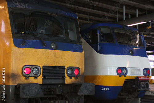 Two trains from the dutch railway system: yellow intercity, white sprinter