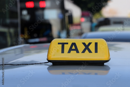 Taxi light sign or cab sign in yellow color with black text on the car roof.