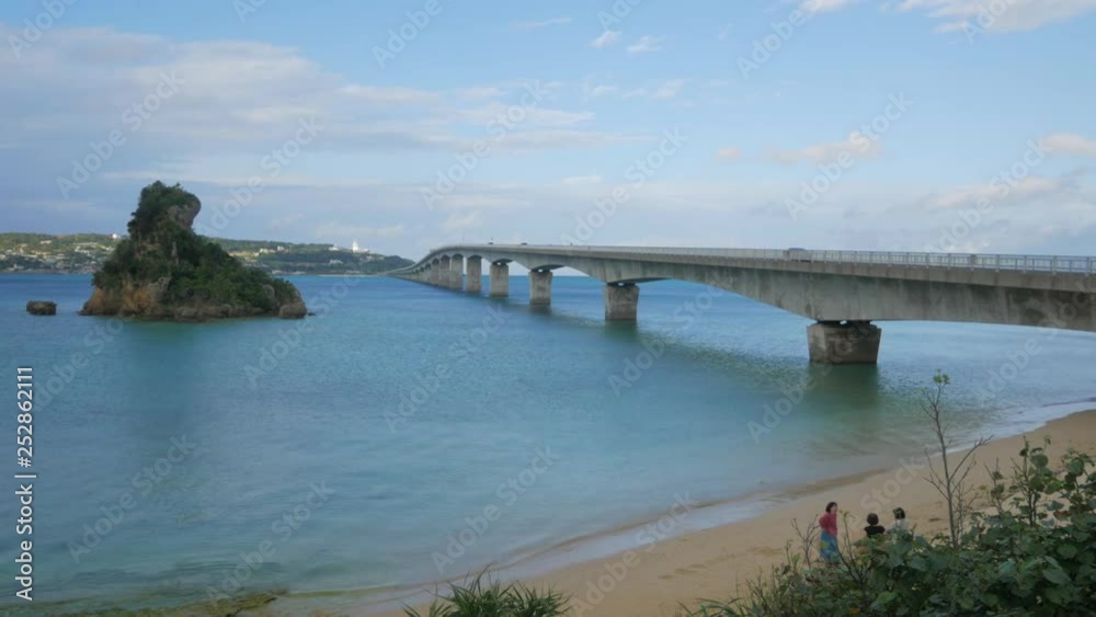 Landscape view of the car bridge cross the okinawa island in Japan with some car on the bridge in summer day time Landscape view of the car bridge cross the okinawa island in Japan with some car on the bridge in summer day time