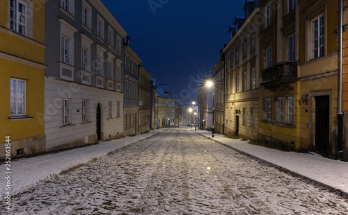 The snow-covered street of the old city in Warsaw during the winter night