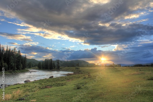 Journey through the wild nature of the Altai. Sunset in  the valley of the  mountain river Bashkaus. Summer landscape - Clean air of Altai and the beauty of Siberia photo