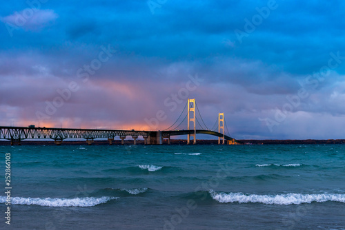 Mackinac Bridge spanning the Straits of Mackinac between the upper and lower peninsulas of Michigan, USA at sunset.
