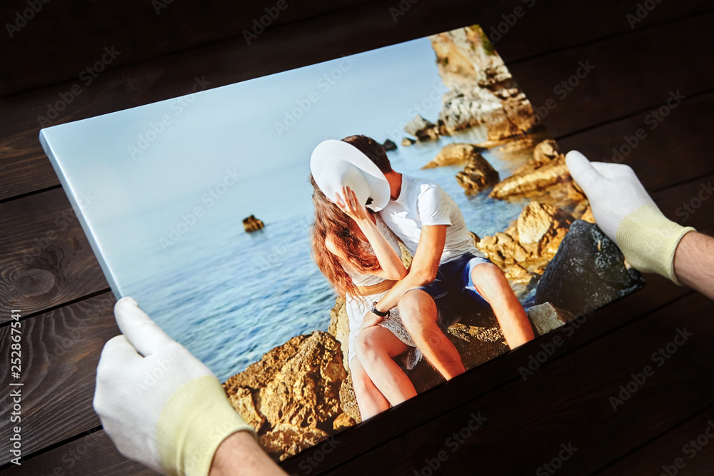 Photography printed on canvas with gallery wrap method of canvas stretching. Photo of kissing couple in love is in male hands - obrazy, fototapety, plakaty 