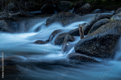Fototapet Blue water flowing over the rocks in a mountain stream in Bishop, California