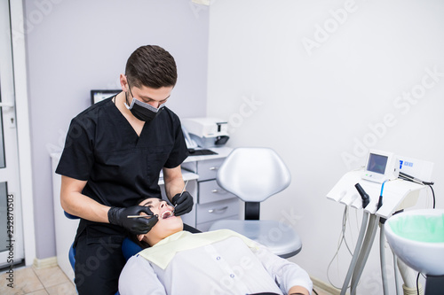 Dentist examines the teeth of the patient on the dentist chair in clinic