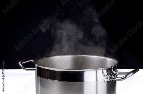 Stainless steel pot with boiling water and steam over it.