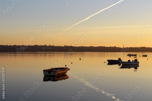 Small boats in the river with sunset colors. Reflection in the water © Sergiodesilva