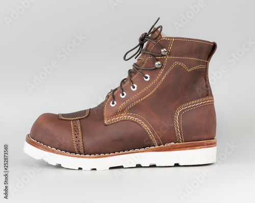 Brown boot with steel toe for biker and leather pad design protection impact from gear. Fashion advertising boot photo isolated on a white background.