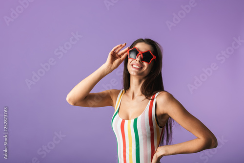 Cheerful young girl wearing swimsuit standing