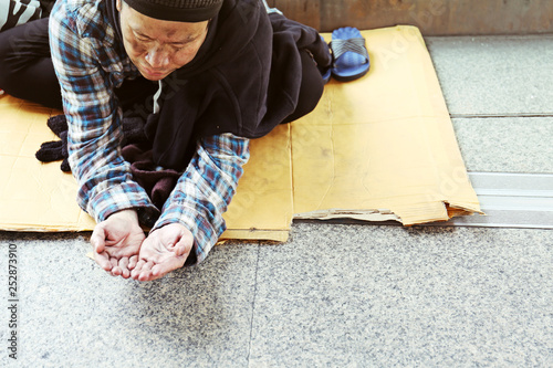 Close-up hand of homeless man and wish money from people on walking street.