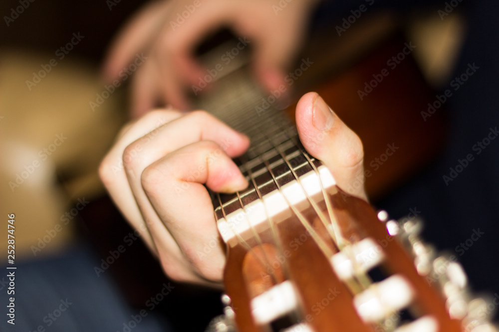 Fototapeta premium Classical guitar in the hands of a young guy.
